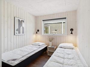 two beds in a room with a window at 5 star holiday home in Dronningmølle in Dronningmølle +35 photos