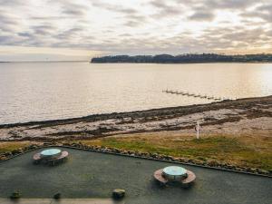 two picnic tables on the shore of a body of water at 2 person holiday home in Hejls in Hejls