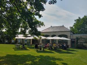eine Gruppe von Menschen, die an Tischen vor einem Gebäude sitzen in der Unterkunft Château de Montigny-sur-Aube in Montigny-sur-Aube