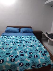 ein Schlafzimmer mit einem Bett mit einer blauen Bettdecke in der Unterkunft Departamentos omill 154 in La Banda