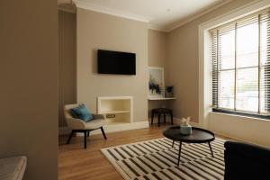 a living room with a tv and a chair and a table at GuestReady - Modern haven with garden in Dublin in Dublin +17 photos