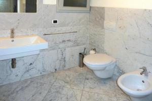a white bathroom with a sink and a toilet at Residence La Chiusa di Rio, Rio nell'Elba in Rio nellʼElba