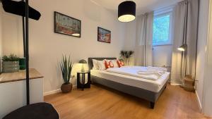 a bedroom with a bed with orange pillows on it at BeckHomes Munich - Stylish Central Apartments in Munich