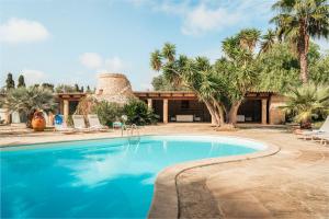 a swimming pool in front of a house with palm trees at Villa Manco 12, Emma Villas in Gagliano del Capo