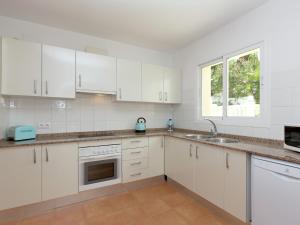 a kitchen with white cabinets and a sink and a window at Sunny Coastal Stay in Zingst in Cumbre del Sol
