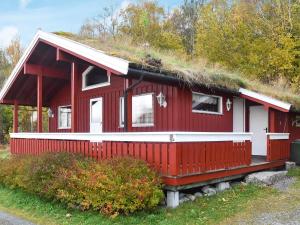 a red house with a grass roof at 6 person holiday home in VATNE-By Traum in Vatne