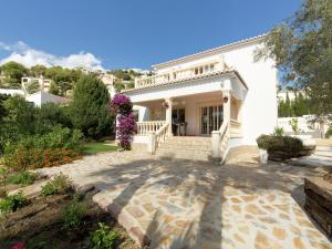 a white house with a staircase and flowers at Sunny Coastal Stay in Zingst in Cumbre del Sol