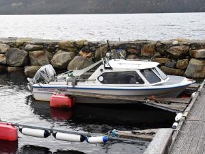a small boat is docked at a dock at 6 person holiday home in Vatne in Vatne