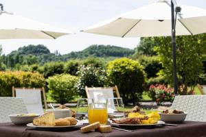 a table topped with plates of food and orange juice at Hotel Canova Sport & Relax in Cavaso del Tomba