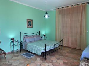 a bedroom with a bed and a blue wall at Casa T Bed and Breakfast & Home Restaurant di Tacchino Simone in Tagliolo Monferrato