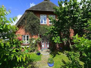 a large brick house with a thatched roof at Ferienwohnung in Oevenum auf Foehr in Oevenum