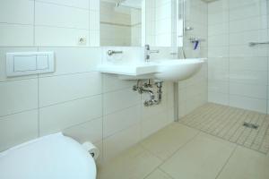 a white bathroom with a sink and a toilet at Holiday apartment in the apartment house at the lighthouse, Plau am See in Plau am See
