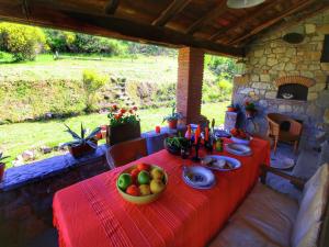 a red table with a bowl of fruit on it at Rustic Holiday Home in Ortignano with Swimming Pool in Castel Focognano