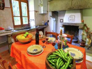 a table with a bowl of green beans and wine glasses at Rustic Holiday Home in Ortignano with Swimming Pool in Castel Focognano