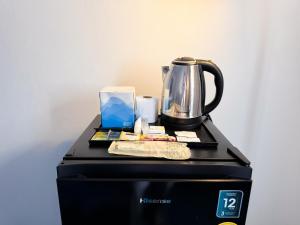 a coffee maker sitting on top of a black washer at ฐิติพร อพาร์ทเม้นต์ บางเขน in Ban Ko