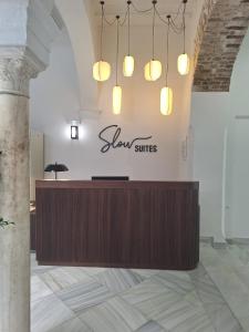 Un vestíbulo con un escritorio con un cartel que dice suites lentas en Slow Suites Salvador, en Sevilla 79 fotos más