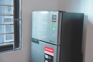 a metal refrigerator in a room next to a window at Biển Xanh 303DM in Hanoi