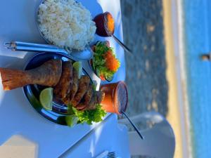 マンガラチバにあるPousada Praia Grandeの米、肉、野菜が入った料理