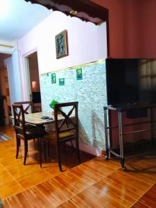 a dining room with a table and chairs and a tv at fayrouzat elmndara near the sea with garden vew in Alexandria