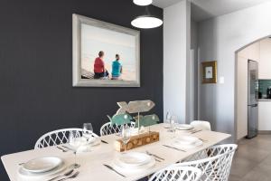 comedor con mesa blanca y sillas blancas en The Bay 4, en Ballito