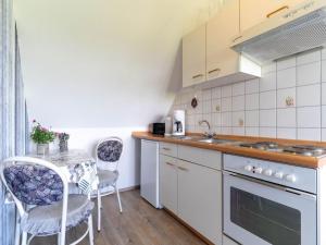 een keuken met een tafel, stoelen en een spoelbak bij Apartments, Toenning in Tönning +32 foto's
