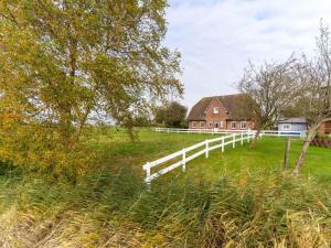 een wit hek in een veld naast een huis bij Apartments, Toenning in Tönning