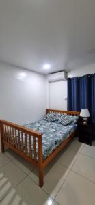 スバにあるBright & Spacious 3BR & Poolの青いカーテンが備わるドミトリールームのベッド1台分です。 +8枚の写真