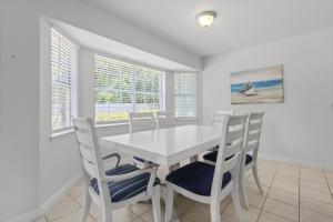 a white dining room with a white table and chairs at Tranquil Haven - Pet Friendly in Perdido Key