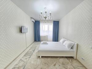 a bedroom with a bed and a chandelier at Mars APARTMENTS KZ 4Б in Aktobe