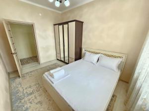 a bedroom with a white bed and a mirror at Mars APARTMENTS KZ 4Б in Aktobe +4 photos