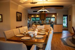 Un comedor con mesa y sillas de madera. en Bokdriftgasteplaas, en Barrydale