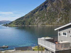 a house on the shore of a lake with a mountain at 4 person holiday home in Selje in Selje
