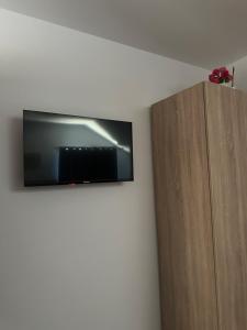 a flat screen tv on a wall next to a wooden cabinet at Casa Aylin in Corbu