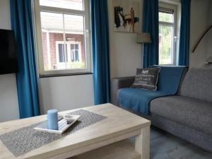 a living room with a couch and a coffee table at Rural holiday home with terrace in Breskens
