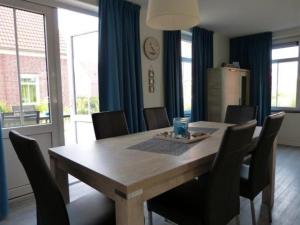 a dining room with a wooden table and chairs at Rural holiday home with terrace in Breskens