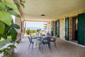 patio con tavolo e sedie di Italian Experience-Il Pino Apartment a San Venanzo
