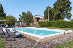una piscina con una sedia e un tavolo di Italian Experience-Il Pino Apartment a San Venanzo