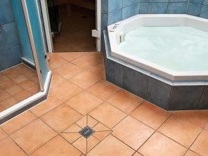 a bathroom with a tub and a tiled floor at 12 person holiday home in GROEMITZ in Grömitz +26 photos