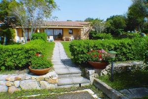 a garden with two pots of flowers and a house at Apartment in Porto Pollo near Sea Beach in Porto Pollo