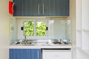 eine Küche mit Spüle und Fenster in der Unterkunft Mobile Homes in Camp Kovacine, Cres, with long pebble beach in Cres + 51 Fotos