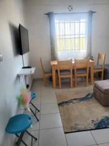 a living room with a table and a dining room at Ranks Comfy Homes in Mombasa +3 photos