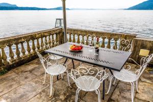 La Villa di Elena في فيربانيا: طاولة مع كراسي ووعاء من الفواكه على شرفة