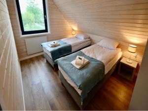 two beds in a small room with a window at Comfortable house by the beach in Stepnica in Stepnica