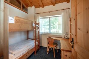 a bedroom with two bunk beds and a desk at Hotel König Laurin in San Genesio Atesino