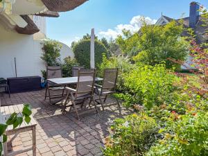un patio con mesa y sillas en un jardín en Moin Moin, en Born