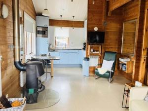 フルスホルストにあるHoliday Home in Hulshorst near Veluwemeer Lakeの青いキャビネットとテーブルと椅子のあるキッチン
