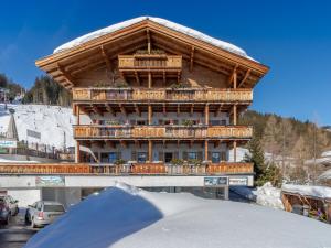 ein großes Holzgebäude mit Balkon im Schnee in der Unterkunft Apartment in Mittersill near Ski Bus & Slopes in Hollersbach im Pinzgau