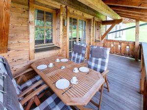 einen Holztisch und Stühle auf dem Deck einer Hütte in der Unterkunft Apartment in Mittersill near Ski Bus & Slopes in Hollersbach im Pinzgau