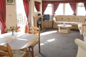 un salon avec une table et un canapé dans l'établissement Mobile home in Kolczewo with a terrace, à Kołczewo