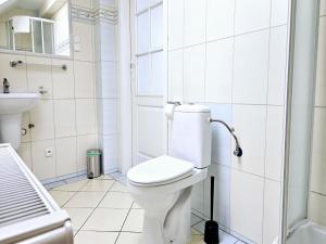 a white bathroom with a toilet and a sink at Comfortable house with private pool, Kolczewo in Kołczewo